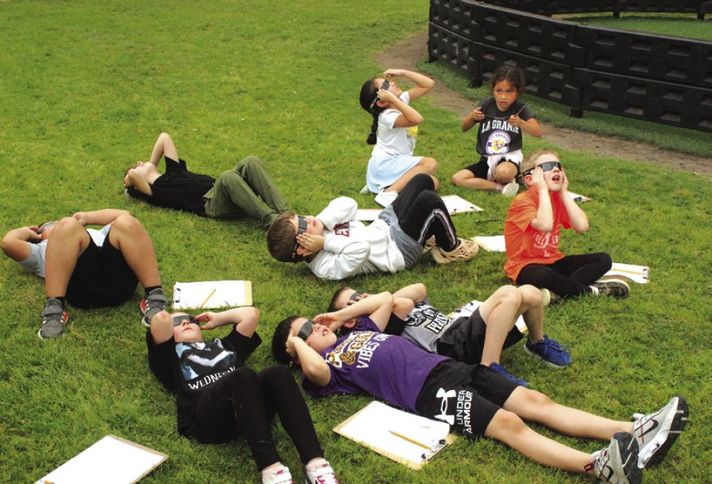 Students in Mrs. Hartmann’s first grade class at La Grange Elementary check out the eclipse Monday before a storm warning sent them hurrying inside. Photo by Jeff Wick